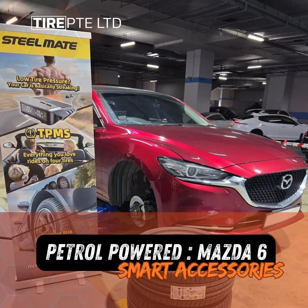 Red mazda sedan on a lift in a dim showroom with a banner advertising steel mate tpms and four tire rides overlaid with bold orange text about petrol powered mazda 6 smart accessories | tire pte ltd | tire pte ltd